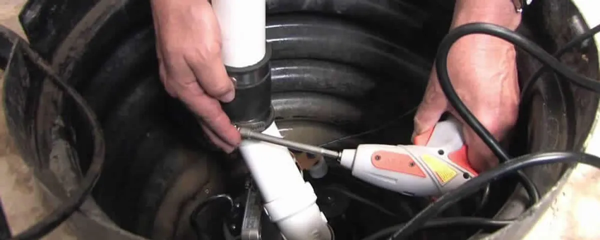Sump pump installation technician connecting PVC discharge piping in Dayton, OH